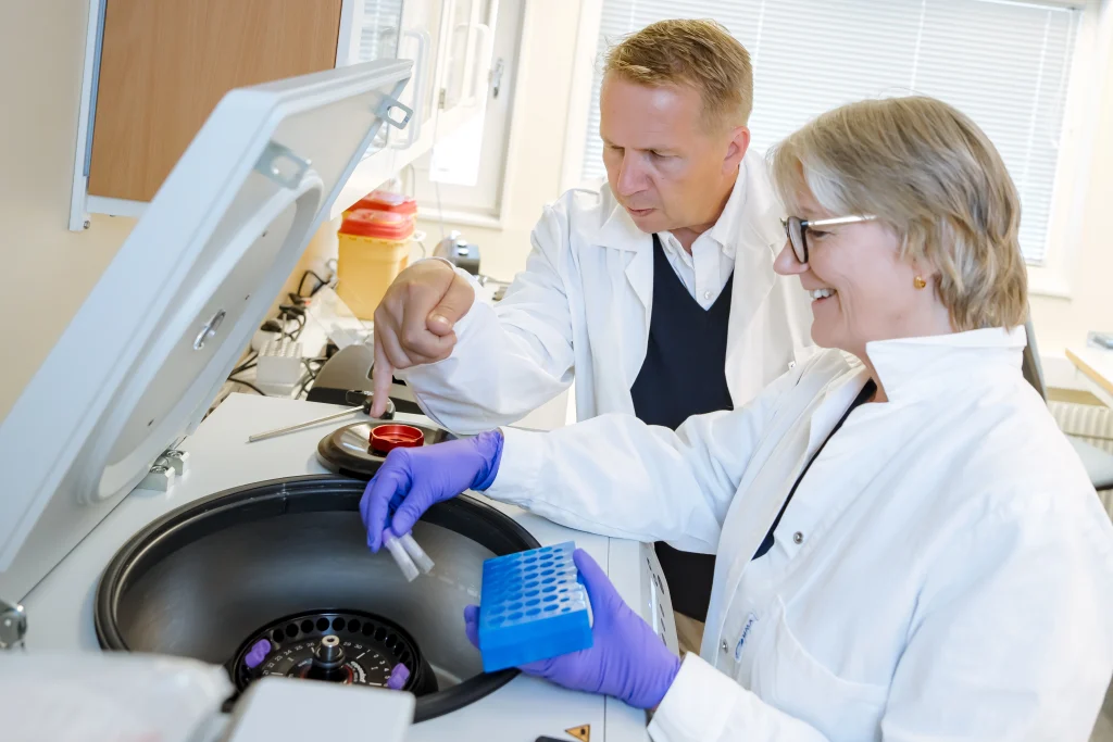 Two people in lab coats working